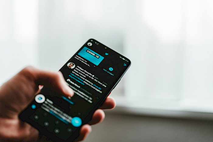 Screenshot of an Android phone in a male hand.