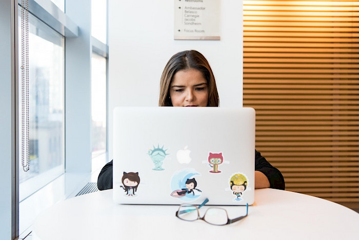 Photo of woman using software on a Mac computer.