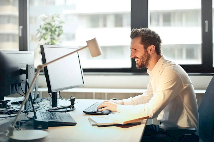 A men writting a newsletter on a PC,